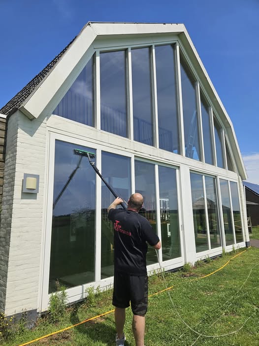 Gevelreiniger wast hoge ramen van woning in Noord-Limburg